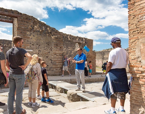 Visitors exploring Pompeii ruins with a tour guide, Naples, Italy.