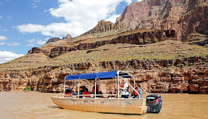 Helicopter flying over Grand Canyon West Rim with view of Colorado River, part of 15-min tour with floor landing and boat ride.