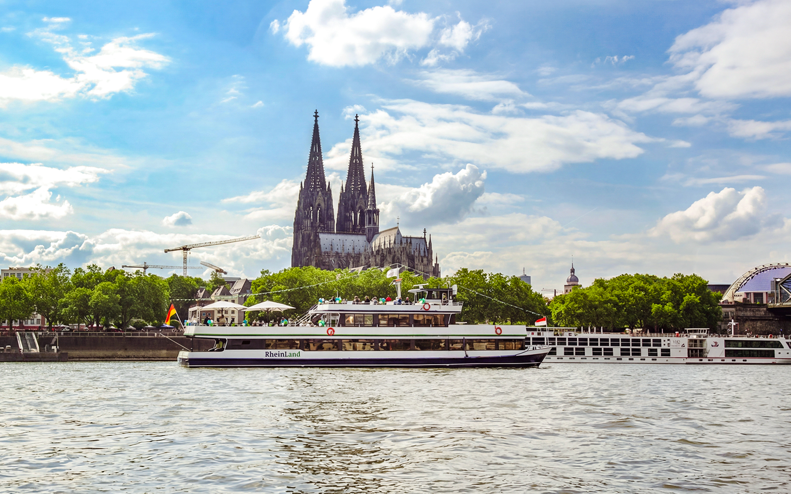 Sightseeing cruise on the Rhine River with Cologne Cathedral in the background.