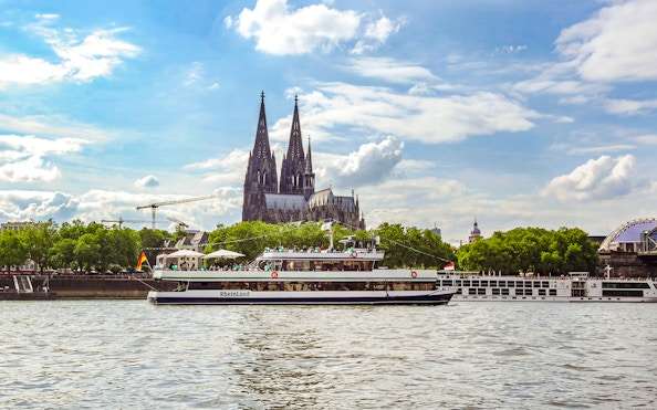 Sightseeing cruise on the Rhine River with Cologne Cathedral in the background.