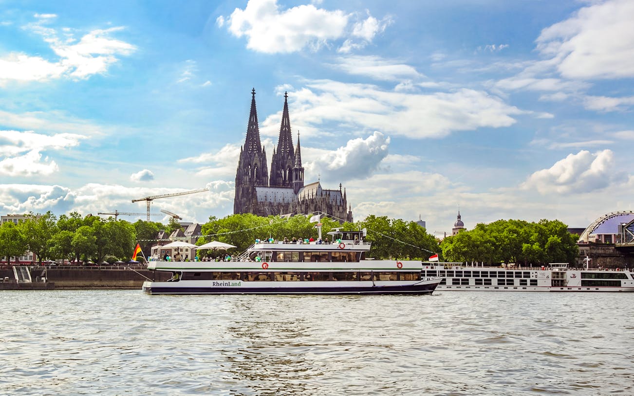 Sightseeing cruise on the Rhine River with Cologne Cathedral in the background.