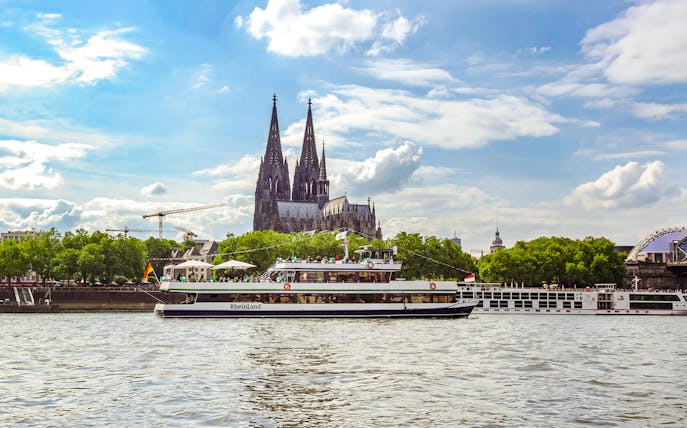 Sightseeing cruise on the Rhine River with Cologne Cathedral in the background.