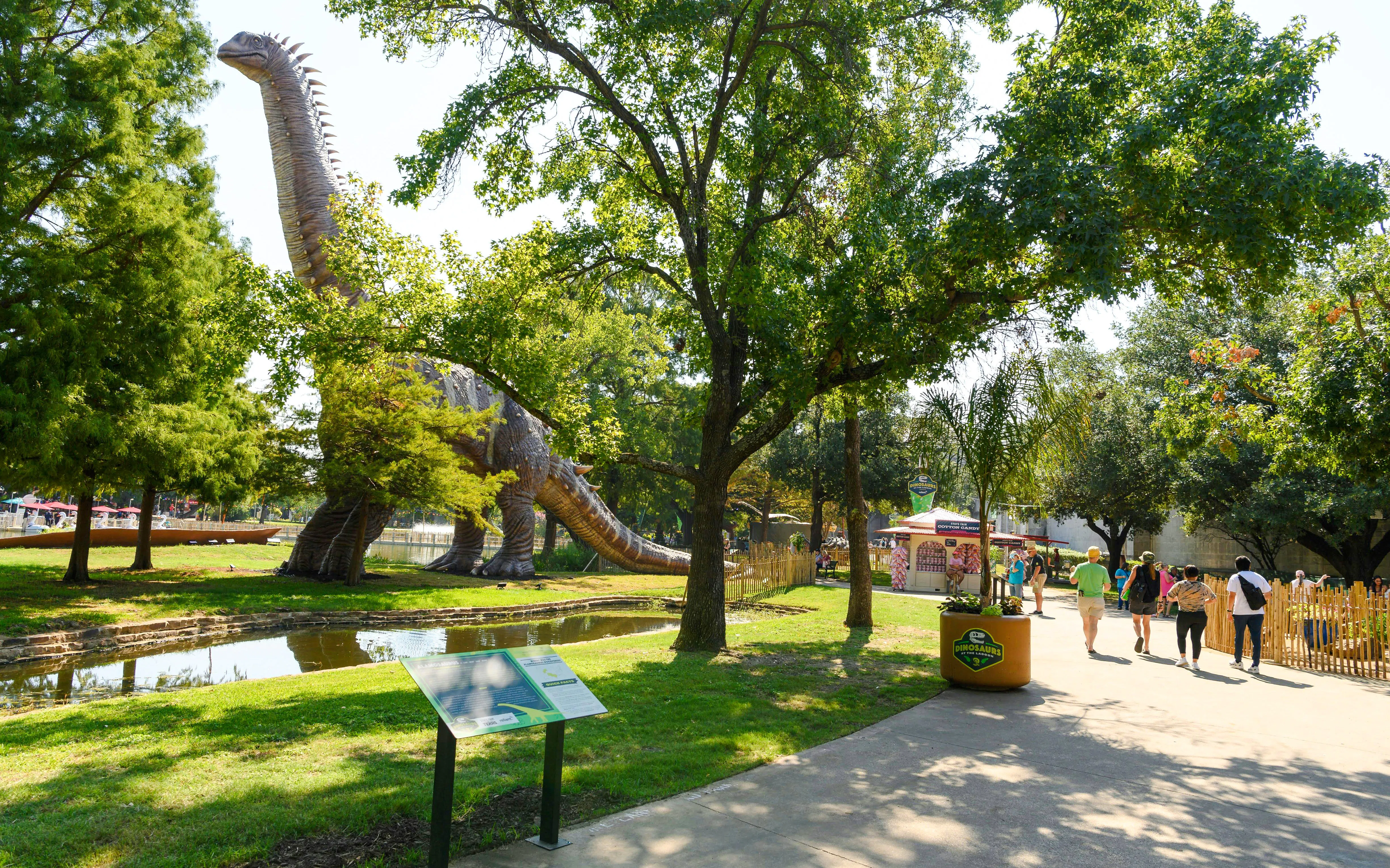 Dinosaur exhibit at the State Fair of Texas with visitors walking nearby.