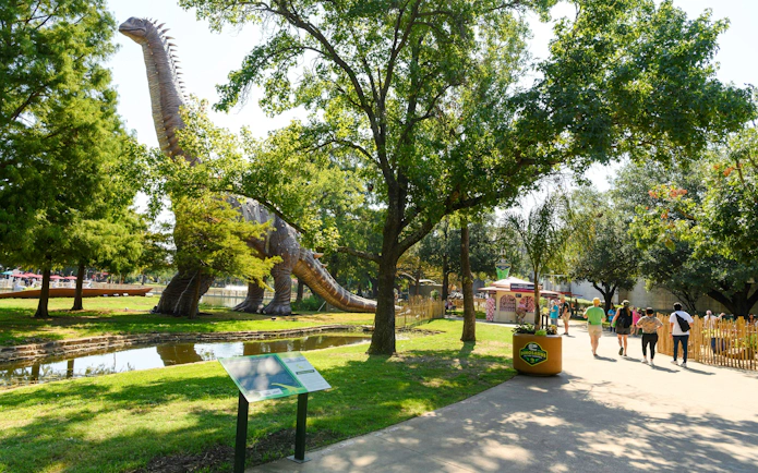 Dinosaur exhibit at the State Fair of Texas with visitors walking nearby.