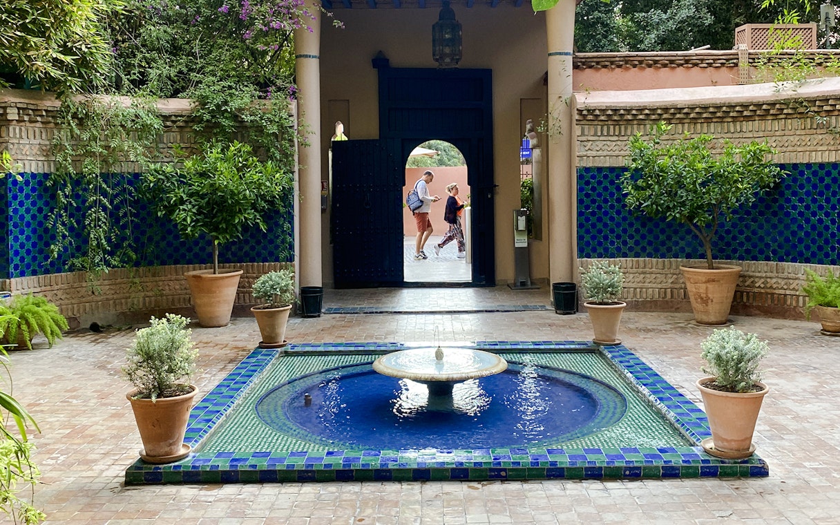 Jardin Majorelle courtyard with blue-tiled fountain and lush greenery.