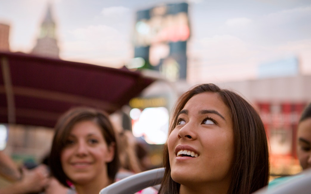 Tourists enjoying a bus tour in Las Vegas with cityscape in the background.