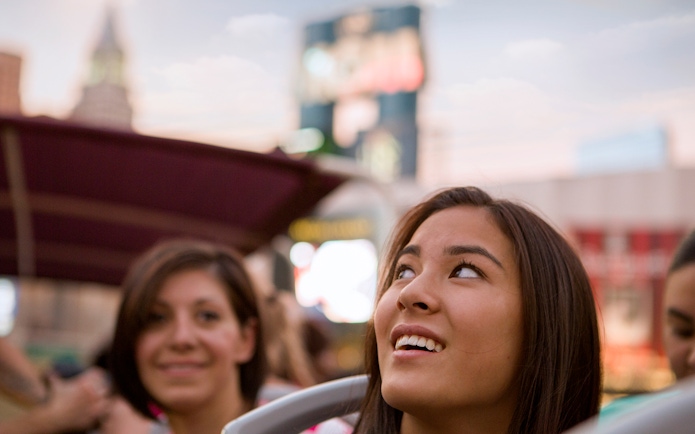 Tourists enjoying a bus tour in Las Vegas with cityscape in the background.