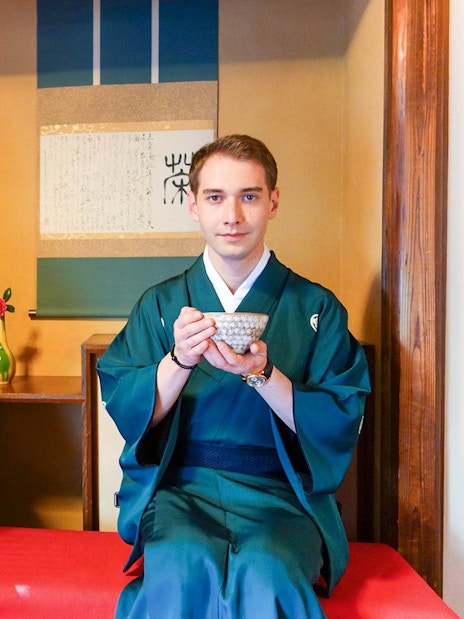 Couple in traditional Japanese attire enjoying tea ceremony indoors.