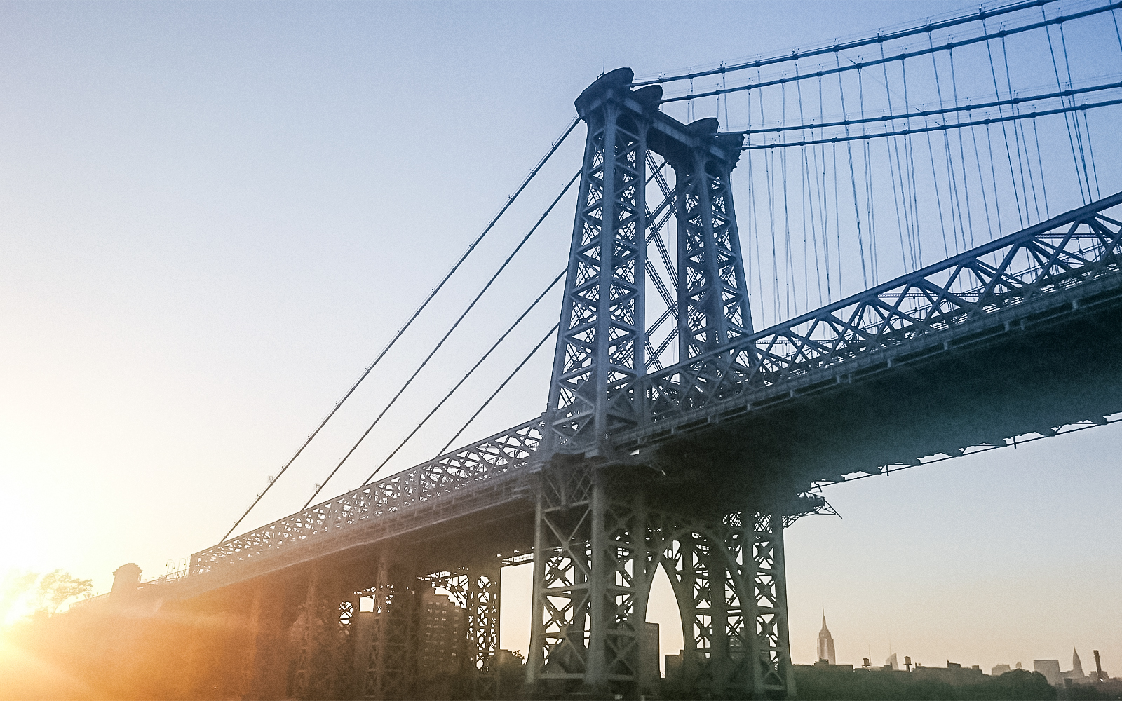 Williamsburg Bridge at sunset during Statue of Liberty Ellis Island cruise.