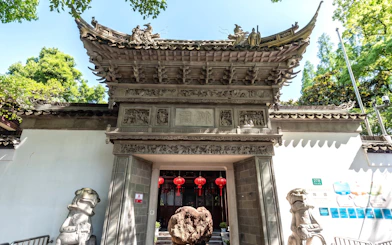 Entrance gate of Yu Garden in Shanghai, China, featuring intricate carvings and stone guardian lions.