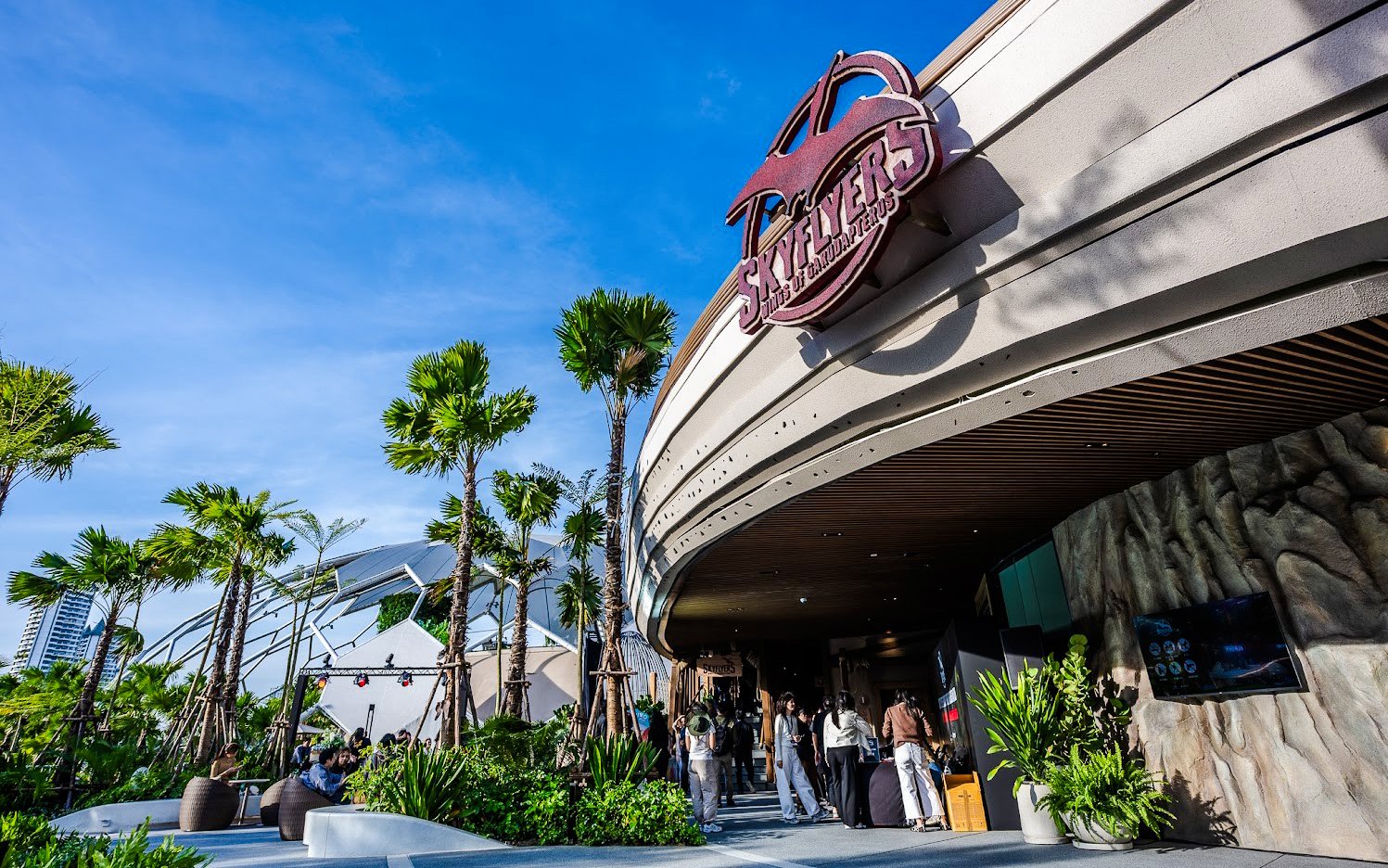 SkyFlyers entrance with palm trees and blue sky at Asiatique Bangkok.
