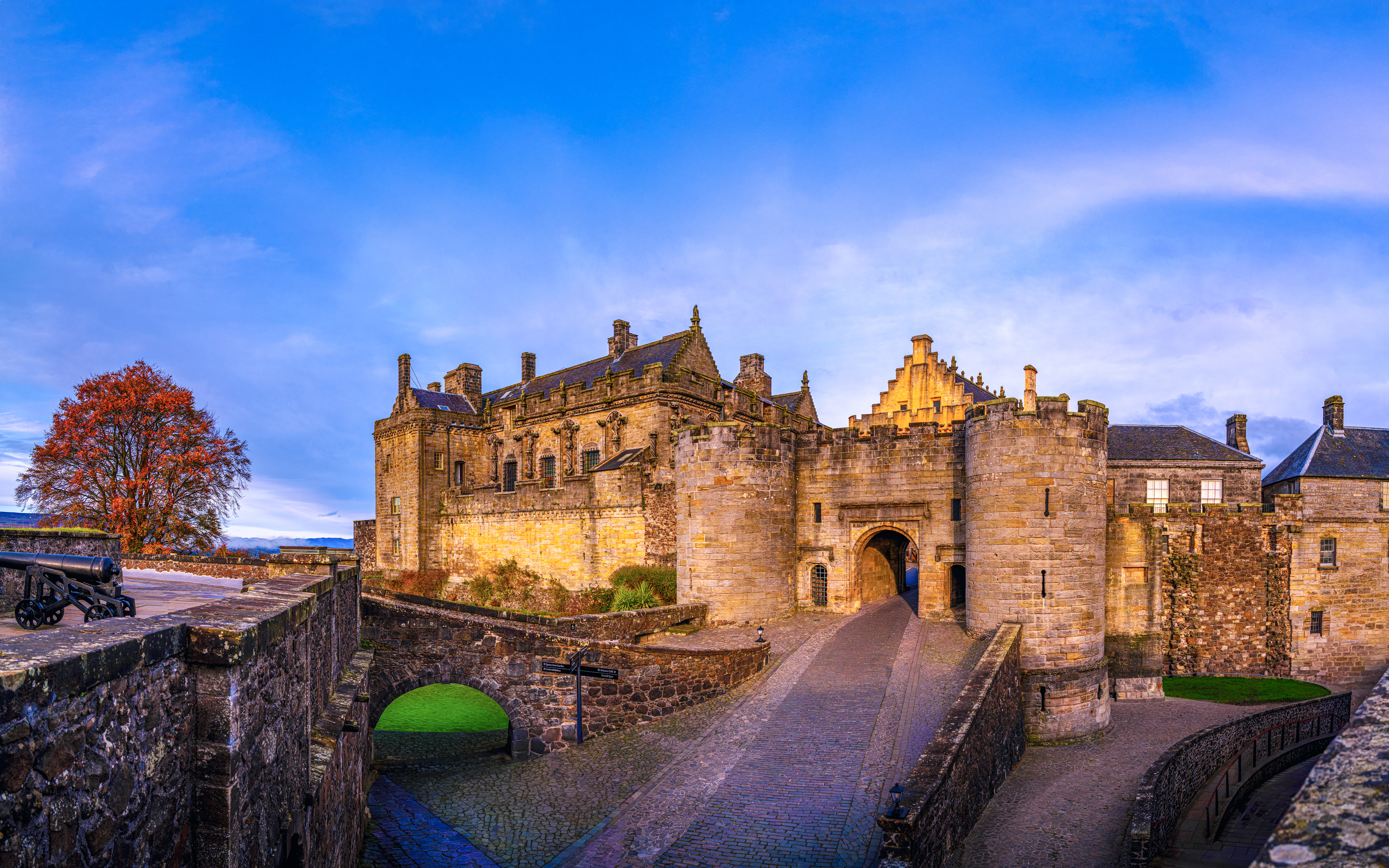 Stirling Castle entrance with stone walls and autumn tree in Scotland, United Kingdom.