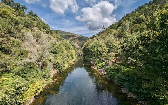 Paiva River flowing through lush forest and mountains in Arouca, Portugal.