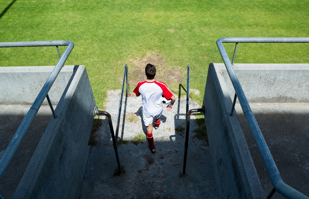 Santiago Bernabeu player tunnel with football field view in Madrid, Spain.