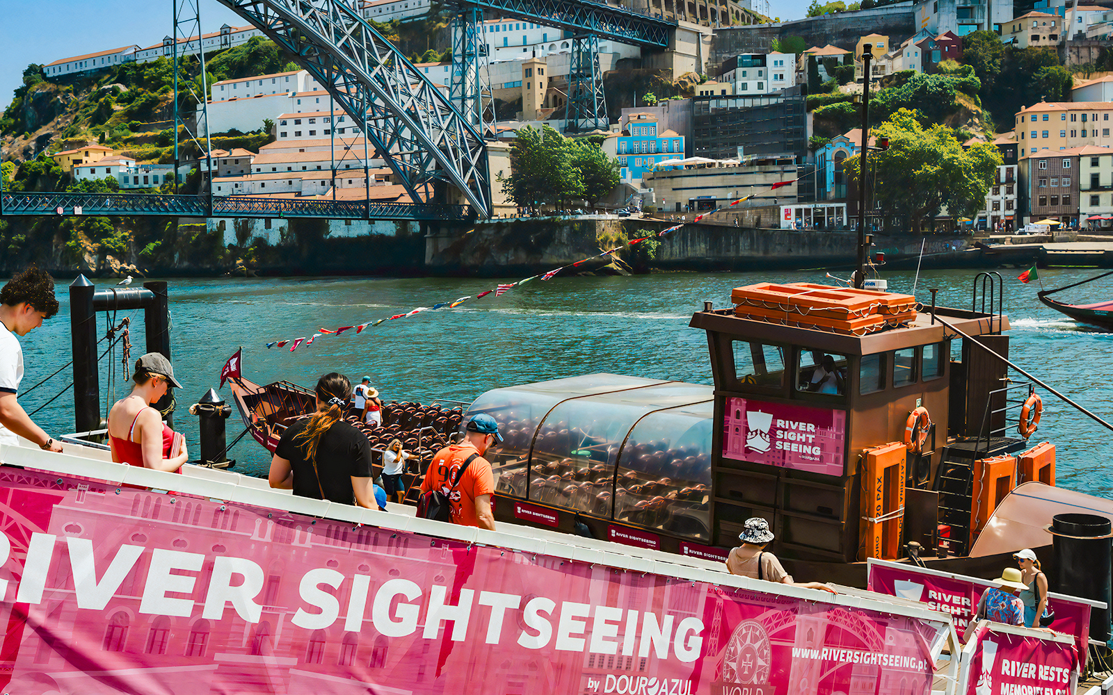 Tourists boarding a sightseeing boat on the Douro River in Porto, Portugal.
