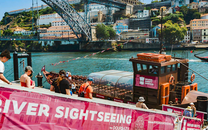 Tourists boarding a sightseeing boat on the Douro River in Porto, Portugal.