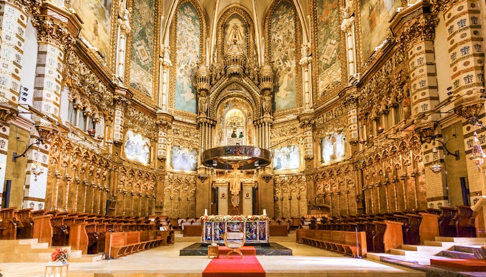 Santa Maria Church at Montserrat Monastery with mountainous backdrop.