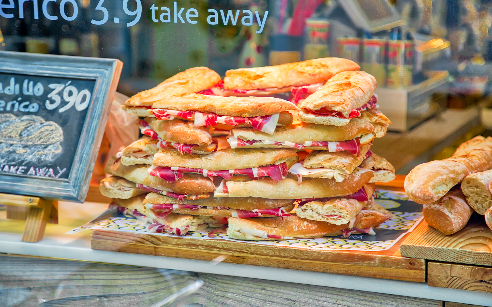 Spanish jamon sandwiches stacked in a Granada city center shop window.