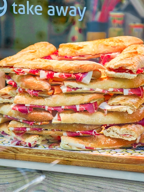Spanish jamon sandwiches stacked in a Granada city center shop window.