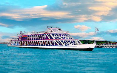 Nile cruise ship with geometric design on the river under a cloudy sky.