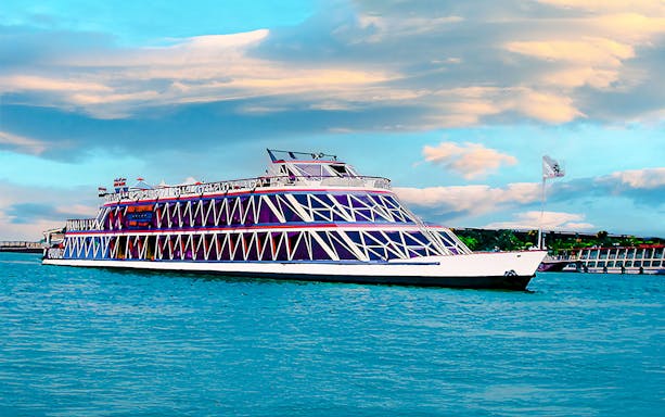 Nile cruise ship with geometric design on the river under a cloudy sky.