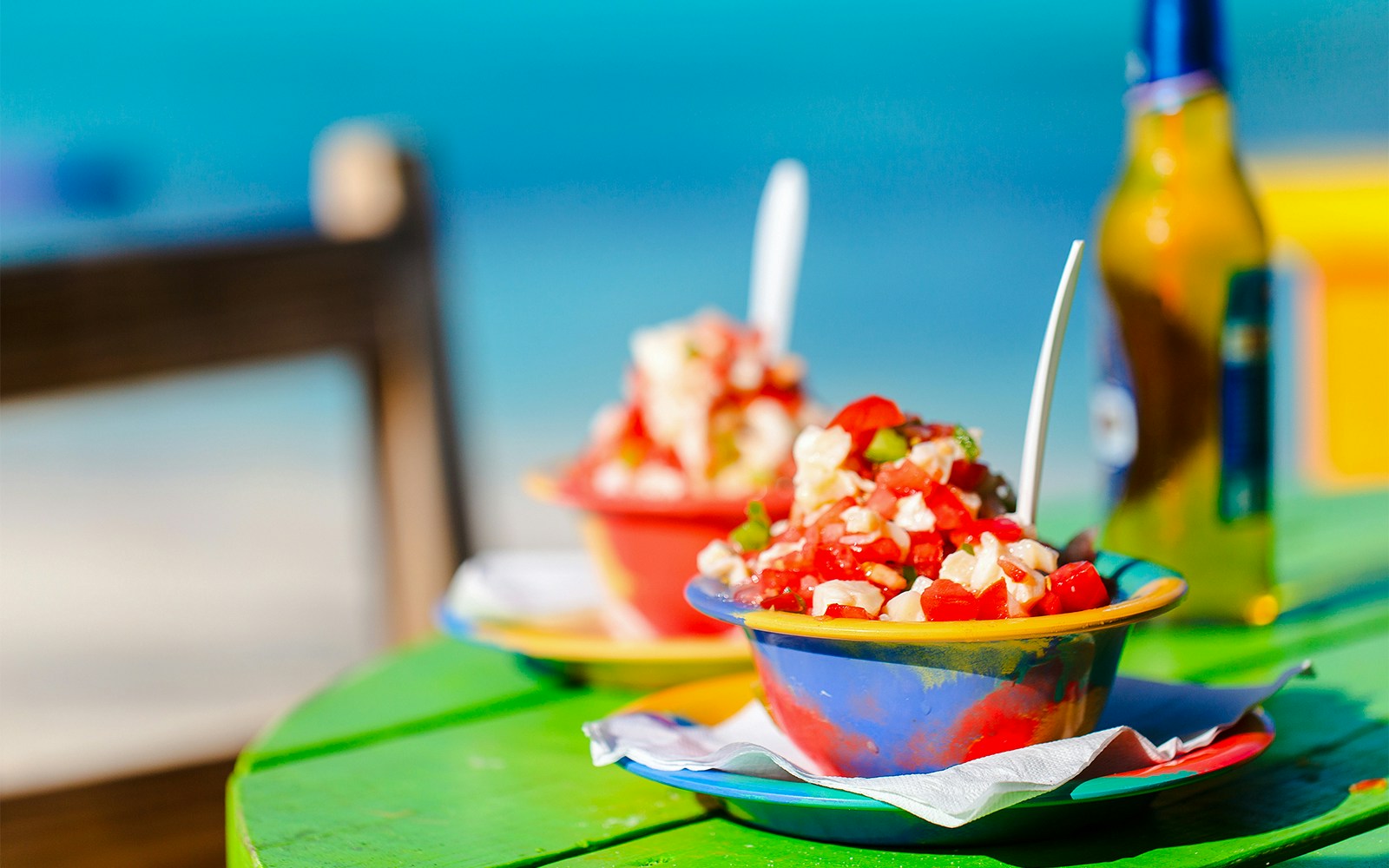 Bahamian conch salad being prepared with fresh ingredients on a beach in Bahamas.