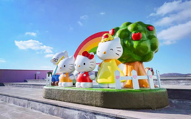 Hello Kitty statues with rainbow and apple tree at Hello Kitty Island.