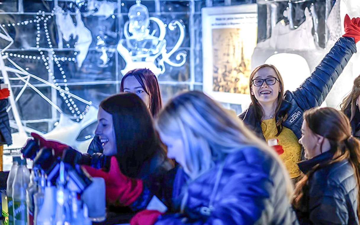 Guests having fun at the Berlin Icebar with ice sculptures in the background.