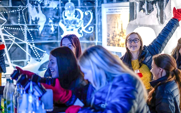Guests having fun at the Berlin Icebar with ice sculptures in the background.