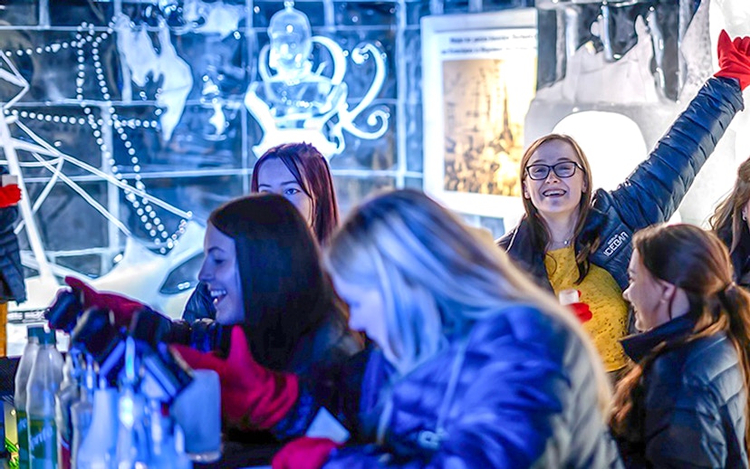 Guests having fun at the Berlin Icebar with ice sculptures in the background.