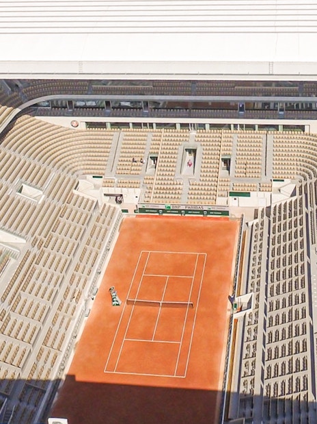 Roland Garros Stadium interior with clay tennis court and surrounding seating area.