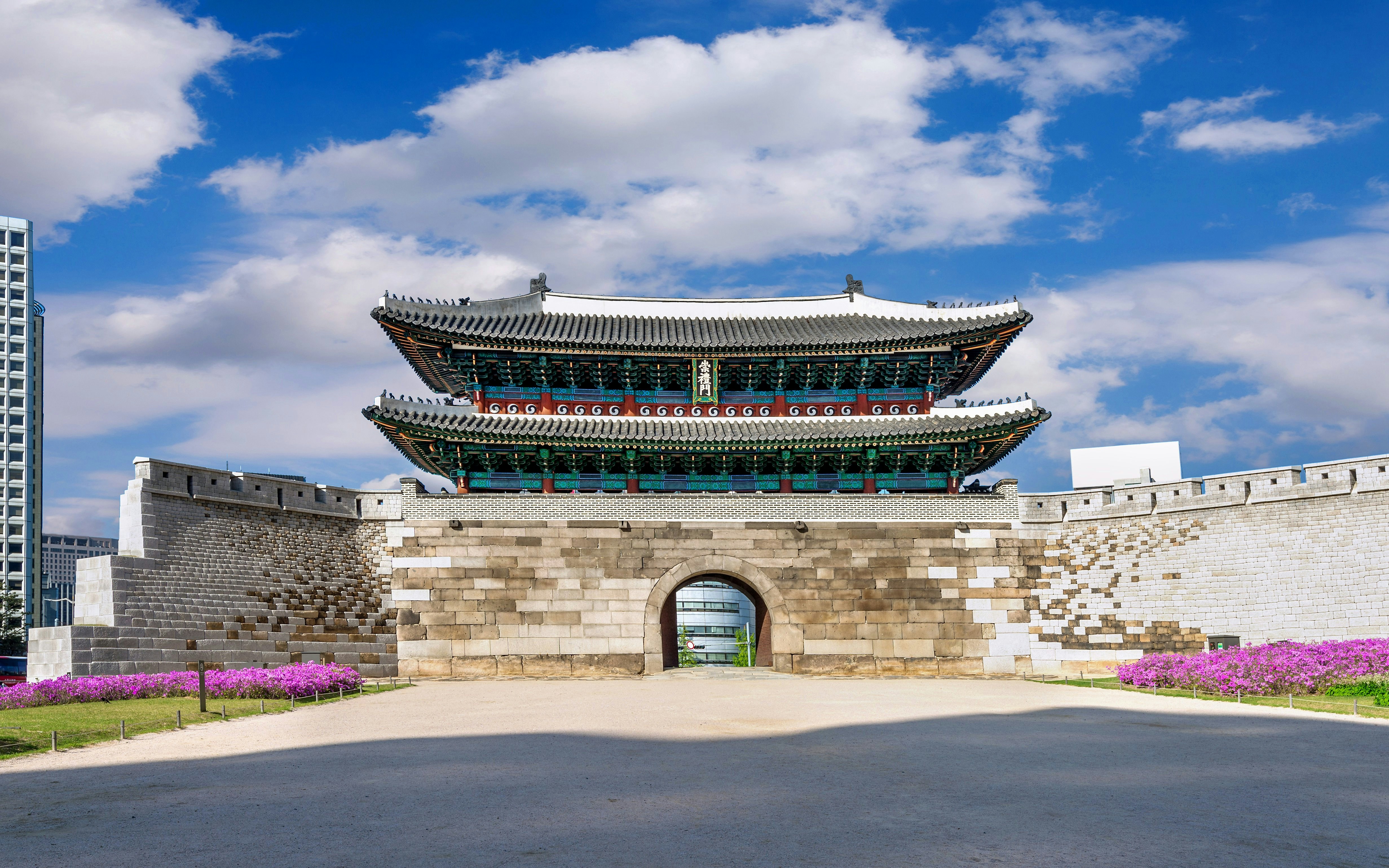 Sungnyemun Gate at Namdaemun Market, Seoul, South Korea, under a blue sky.