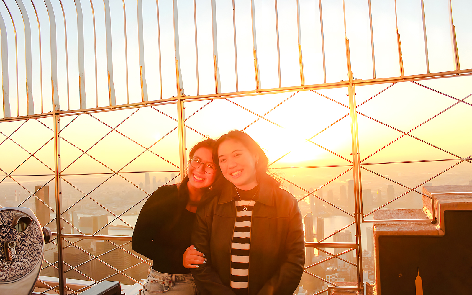 Guests enjoying sunset views from the Empire State Building observation deck.