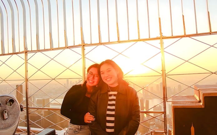 Guests enjoying sunset views from the Empire State Building observation deck.