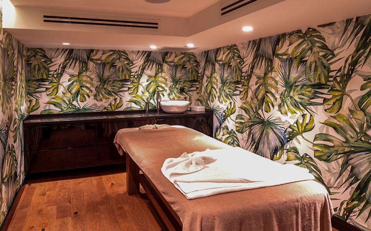 Massage table in Istanbul private Turkish bath with tropical decor.