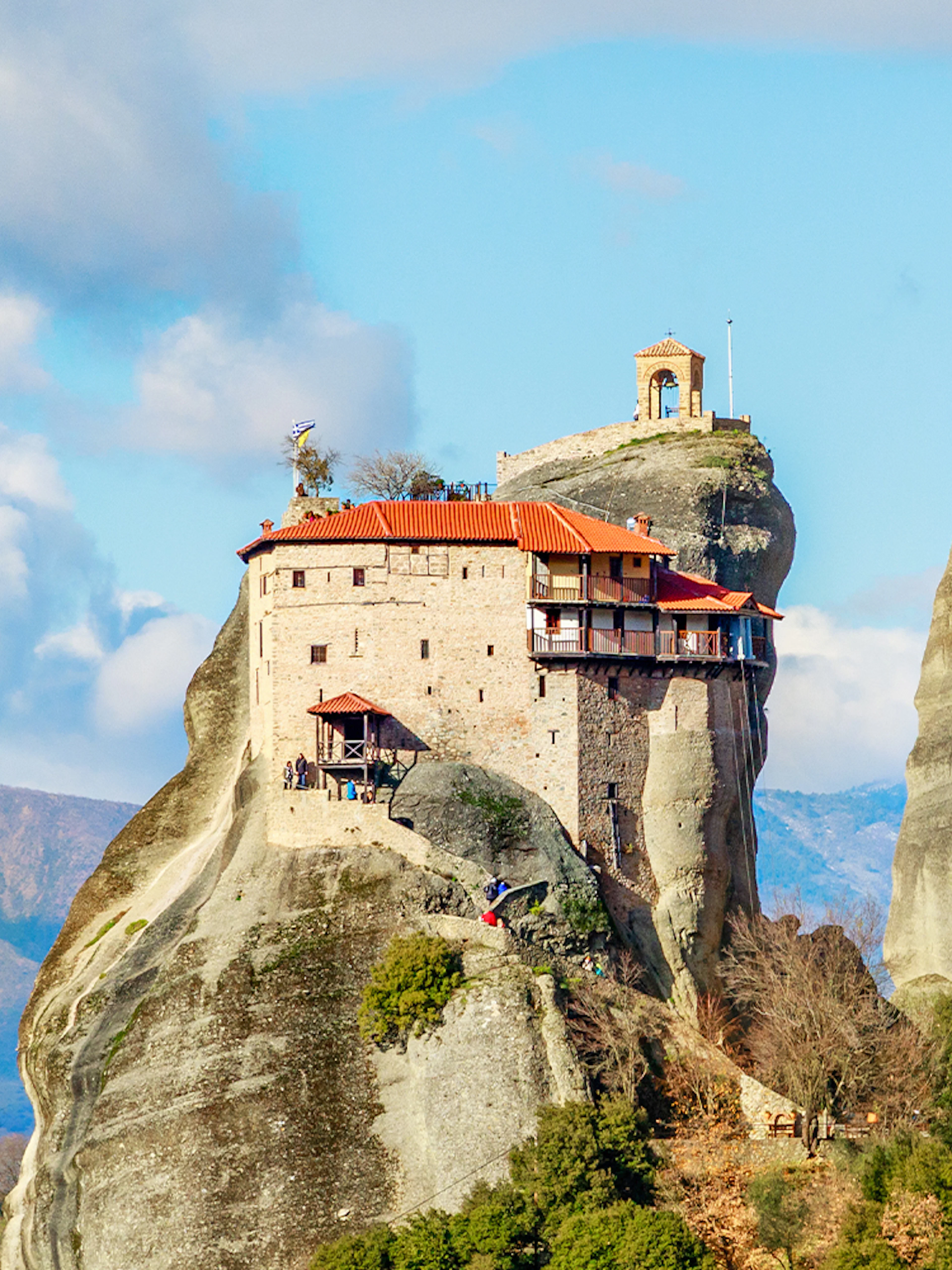 Monastery perched on rock formation in Meteora, Greece, part of private day tour from Athens.