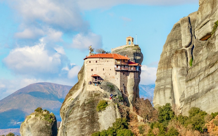 Monastery perched on rock formation in Meteora, Greece, part of private day tour from Athens.