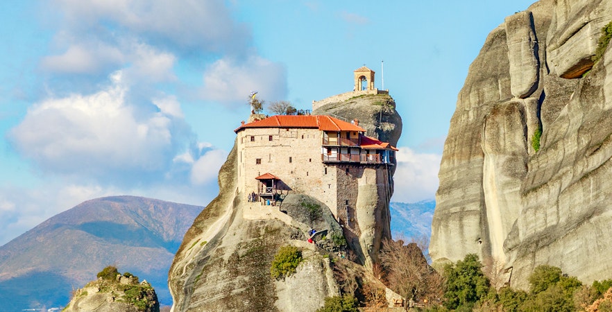 Monastery perched on rock formation in Meteora, Greece, part of private day tour from Athens.