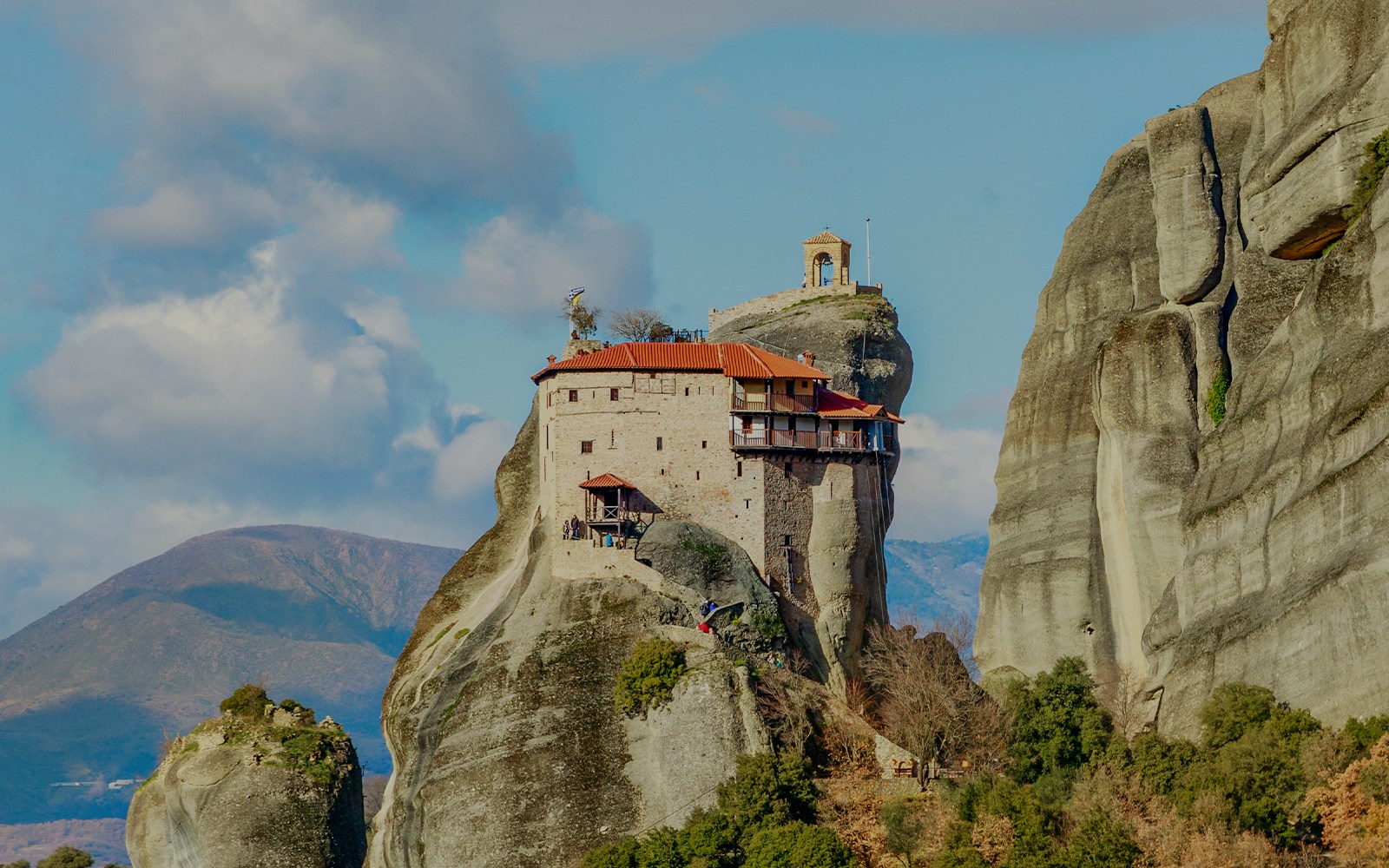 Monastery perched on rock formation in Meteora, Greece, part of private day tour from Athens.