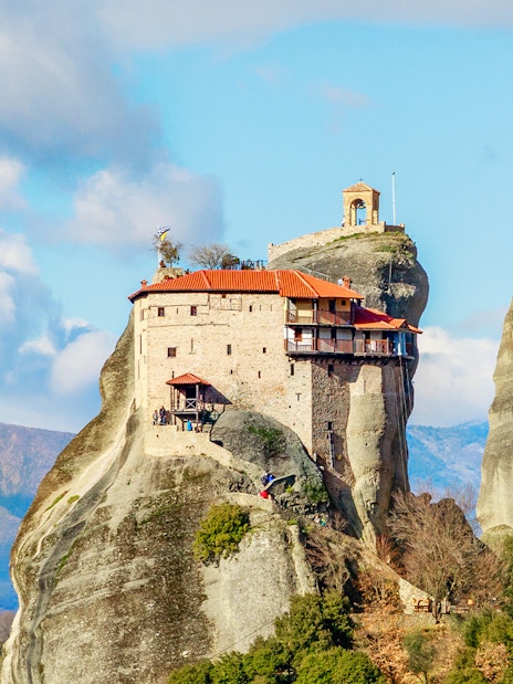 Monastery perched on rock formation in Meteora, Greece, part of private day tour from Athens.