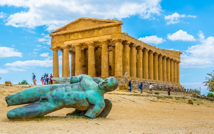 Ancient Greek temple and fallen statue in Agrigento, Sicily, during minivan tour.
