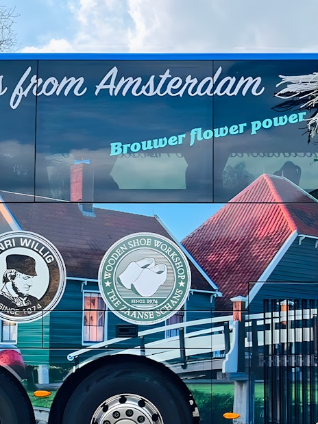 Roundtrip AC coach with Amsterdam tour branding and scenic imagery.