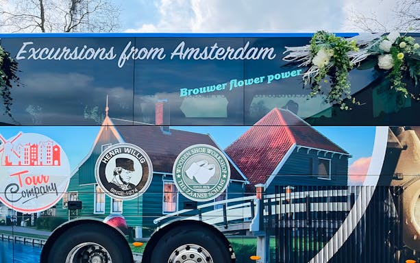Roundtrip AC coach with Amsterdam tour branding and scenic imagery.