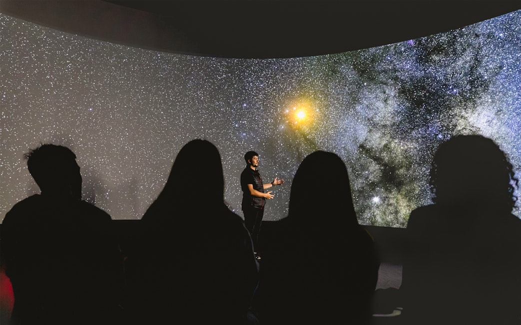 Tourists watching a starry sky presentation at Dark Sky Indoor Cultural Astronomy Experience.