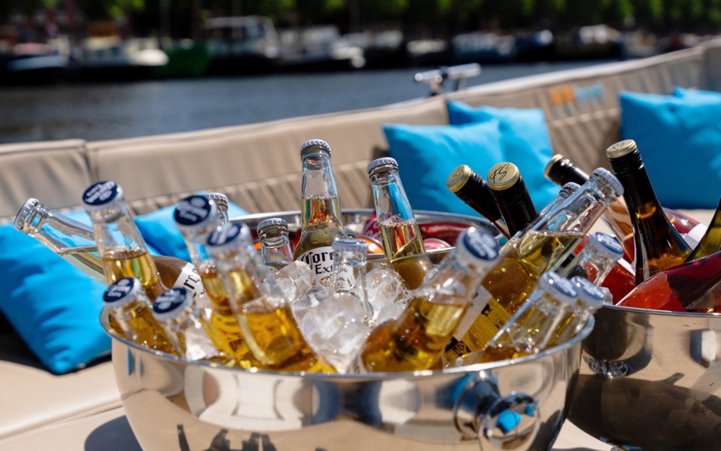 Beverages in ice bucket on open boat during Utrecht canal cruise.