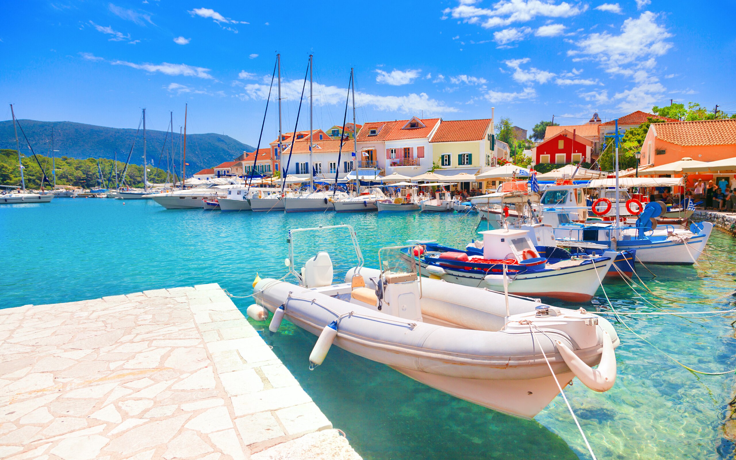 Boats docked at Fiskardo village harbor, Kefalonia island, Greece.