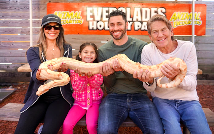Guests holding a large snake at Everglades Holiday Park animal encounter.