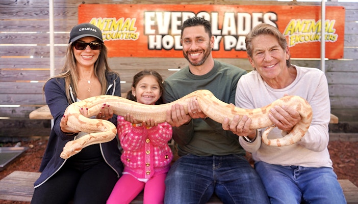 Guests holding a large snake at Everglades Holiday Park animal encounter.