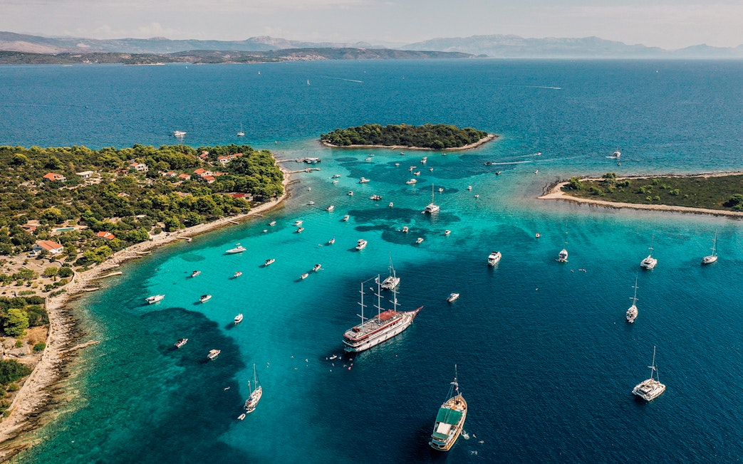 Aerial view of boats in the Blue Lagoon, Croatia, surrounded by turquoise waters and lush islands.