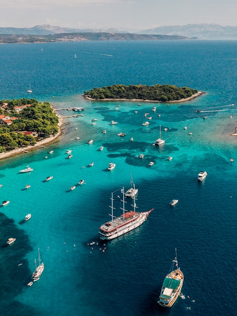Aerial view of boats in the Blue Lagoon, Croatia, surrounded by turquoise waters and lush islands.